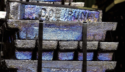 A pile of bluish silver lead bars stamped with “Doe Run.”