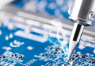 Soldering iron applying tin to a circuit board for electrical connections.