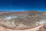 Aerial view of an enormous open pit mine in a high-desert setting.
