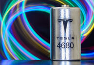 A Tesla 4680 lithium-ion battery cell against a backdrop of swirled colors.