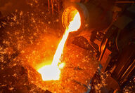 Molten metal from a conventional blast furnace being poured into a mold.