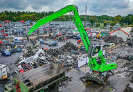 Bright green SENNEBOGAN scrap handler at SYNETIQ recycling yard.