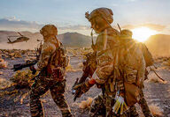 Three fully equipped U.S. combat soldiers during desert training exercises.