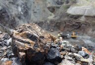 Closeup of a chunk of manganese ore at a mine.